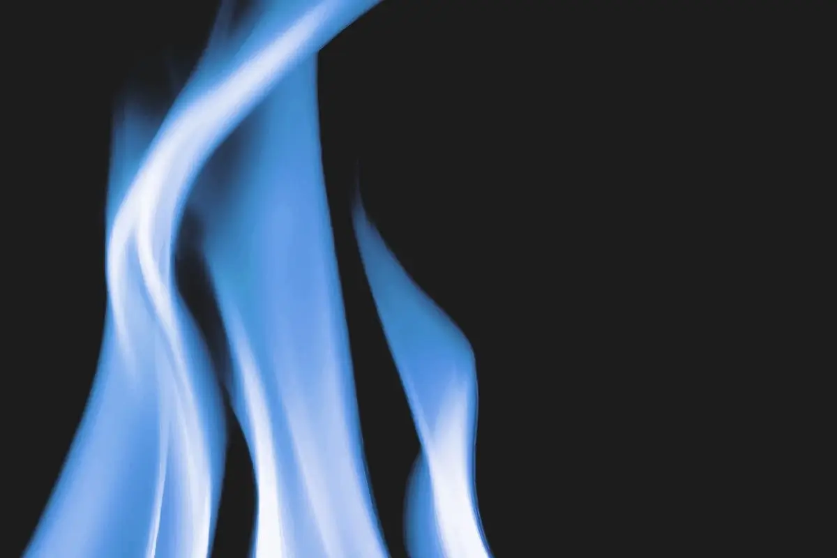 Tri modré plamene zemného plynu na čiernom pozadí symbolizujúce plynové revízie a bezpečnosť